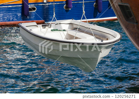 Small white boat is suspended above water Small white boat is suspended above water 120256271
