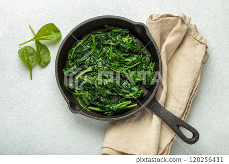 Healthy steamed spinach leaves in cast iron pan on white background top view 120256431