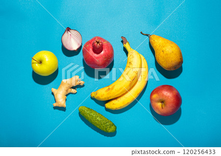 Fresh fruits and vegetables on blue backdrop, colorful and vibrant, top view, high contrast with hard light 120256433