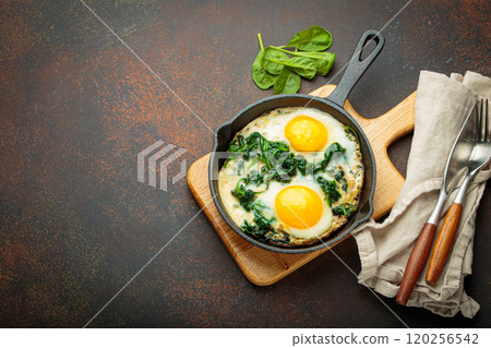 Healthy spinach omelette in cast iron pan top view, space for text Healthy spinach omelette in cast iron pan top view, space for text 120256542