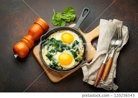 Healthy spinach omelette in cast iron pan for breakfast top view 120256543