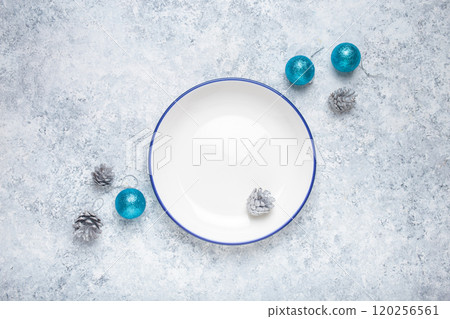 Empty plate with christmas pine cones and baubles on gray background 120256561