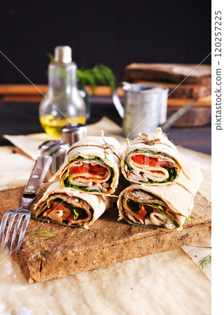 Sliced sandwich tortilla with tomatoes , salad , cream cheese and ham . Sliced sandwich tortilla with tomatoes , salad , cream cheese and ham . 120257225