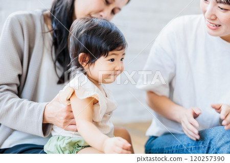 Mom and grandma playing with baby in the living room 120257390