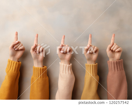 Five hands in colorful sweaters pointing upward, representing unity, teamwork 120257542