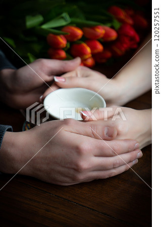 Female and man hands holding cup of coffee. Lovely couple holding cup of coffe in hands 120257551