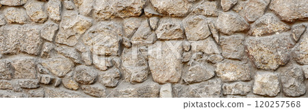 Old coarse pattern panoramic stone wall made of various square natural stones and blocks in beige, ocher and brown 120257568
