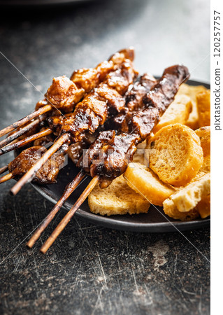 Japanese chicken yakitori and roasted bread on black table. 120257757
