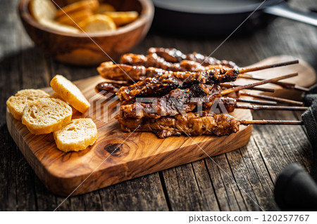 Japanese chicken yakitori on cutting board on wooden table. Japanese chicken yakitori on cutting board on wooden table. 120257767