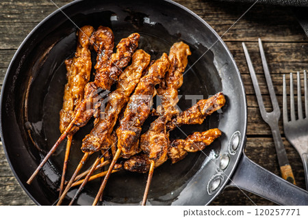 Japanese chicken yakitori on pan on wooden table. Top view. Japanese chicken yakitori on pan on wooden table. Top view. 120257771