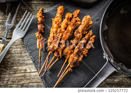 Japanese chicken yakitori on cutting board on wooden table. Top view. Japanese chicken yakitori on cutting board on wooden table. Top view. 120257772