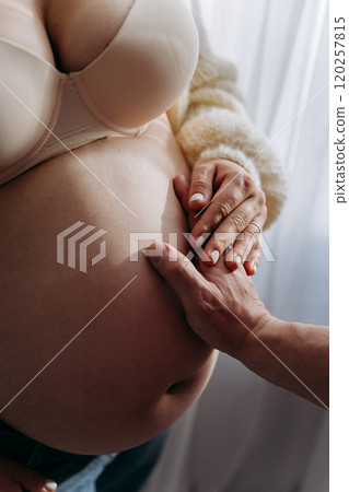 Gentle hands on a baby bump, celebrating love, connection, and the journey to parenthood 120257815