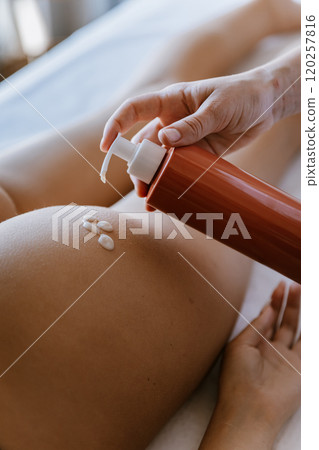 Applying lotion on skin for smooth, hydrated, and rejuvenated results during spa body care session Applying lotion on skin for smooth, hydrated, and rejuvenated results during spa body care session 120257816