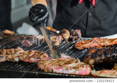 Chef Grilling Steaks Over Open Flame 120258423