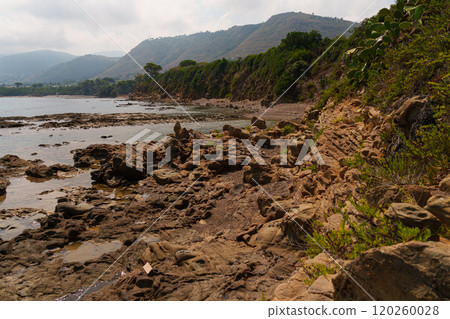 Rocky Coastal Path with Greenery and Distant Hills 120260028