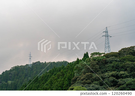 Electricity transmission tower towering over the mountain Electricity transmission tower towering over the mountain 120260490