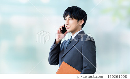 Smiling male businessman talking on a smartphone 120261908