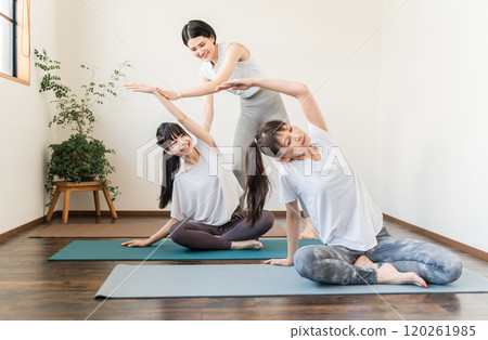 一名女瑜伽老師/教練和一名女學生在瑜伽課/普拉提上教授瑜伽 120261985