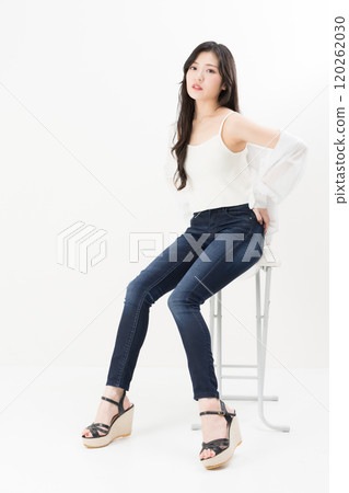 穿著緊身牛仔褲、牛仔褲和牛仔褲的年輕女子 穿著緊身牛仔褲、牛仔褲和牛仔褲的年輕女子 120262030