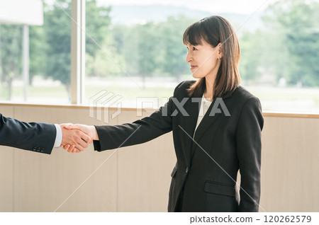商人在公司辦公室/會議室握手並簽訂合約 120262579
