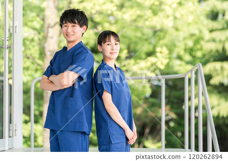 醫院和設施前穿著手術服的男女醫護人員（職能治療師、護士） 120262894