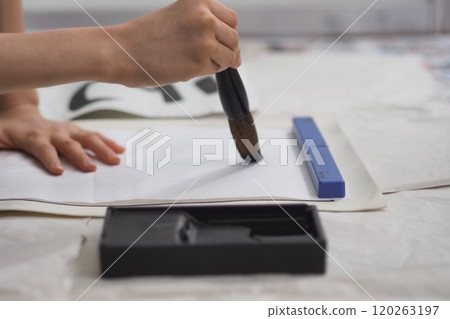 Calligraphy (child's hand holding a large brush) 120263197
