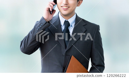 Smiling male businessman talking on a smartphone 120266222