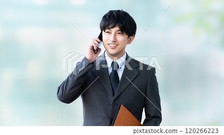 Smiling male businessman talking on a smartphone 120266223