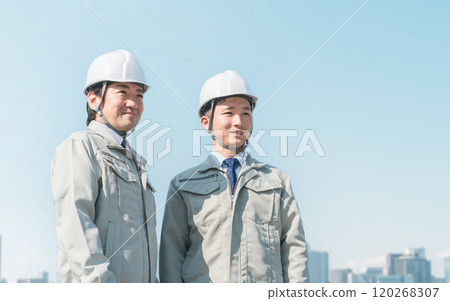 Workers wearing work clothes standing in the blue sky (construction, architecture, design, real estate, civil engineering, construction, site supervision, transportation) Workers wearing work clothes standing in the blue sky (construction, architecture, design, real estate, civil engineering, construction, site supervision, transportation) 120268307