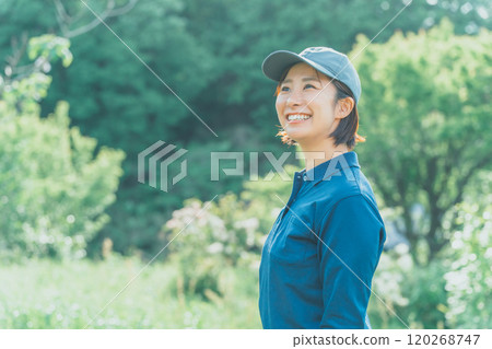 A working woman wearing a blue polo shirt and a blue cap A working woman wearing a blue polo shirt and a blue cap 120268747
