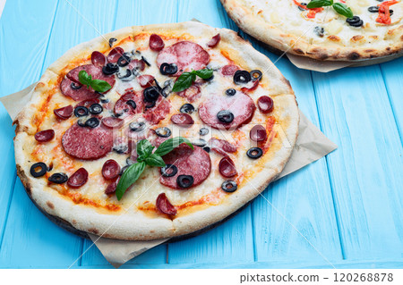 2 pizza with mozzarella cheese , salami sausages , olives , chicken , pineapple and tomatoes 120268878