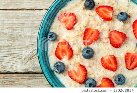Homemade breakfast . Oatmeal with milk and berries . Top view 120268934