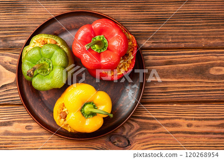 Baked stuffed pepper ( paprika ) with rice , carrot and meat . Top view on rustic background Baked stuffed pepper ( paprika ) with rice , carrot and meat . Top view on rustic background 120268954