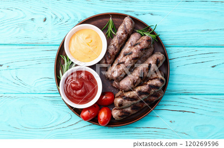 Grilled beef sausages with rosemary sauce and tomatoes photography . Top view 120269596