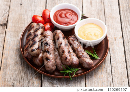 Grilled beef sausages with rosemary sauce and tomatoes photography . Top view 120269597