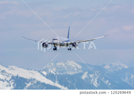 A passenger plane lands between mountains in the northern lands 120269649