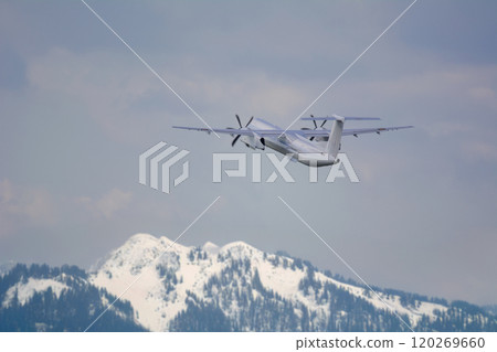 A propeller plane flying with the northern mountains in the background 120269660