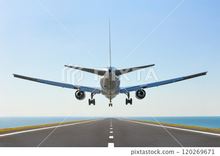 A passenger plane landing on a runway surrounded by sea A passenger plane landing on a runway surrounded by sea 120269671