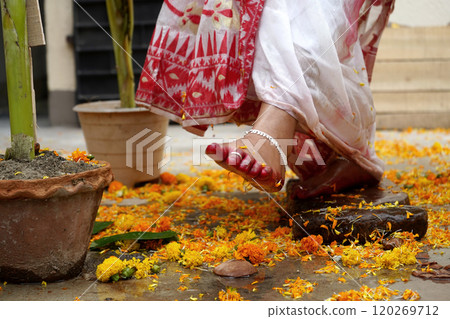 Bengali bride breaking clay pot with her feet as this is traditional rituals of Bengali Marriage 120269712