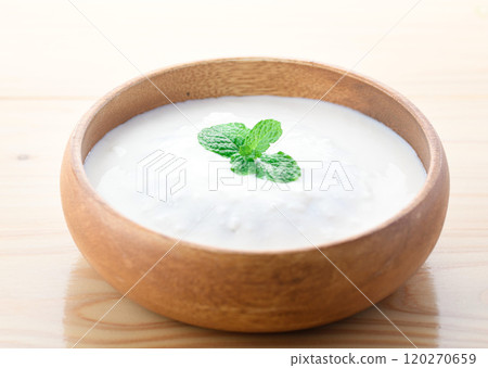 Yogurt served in a wooden bowl (plain yogurt) 120270659