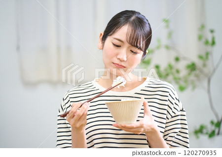 Young woman eating rice, loss of appetite, bad rice 120270935