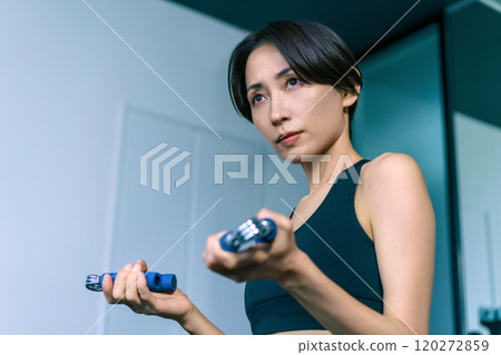 在健身房裡用手柄訓練手臂的女人 在健身房裡用手柄訓練手臂的女人 120272859