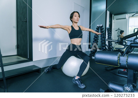 一名女子在健身房進行平衡球訓練 120273233