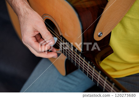 Guitarist on acoustic guitar playing melody. Close up musician instrument with pick in hand 120273680