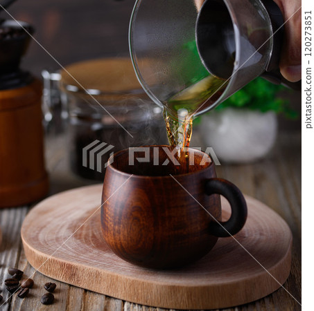 Enjoying coffee in a wooden mug 120273851