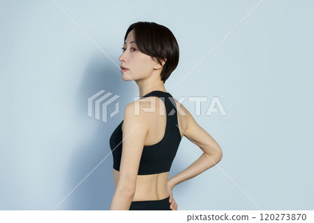 白色背景中穿著健身服的側身女人 120273870