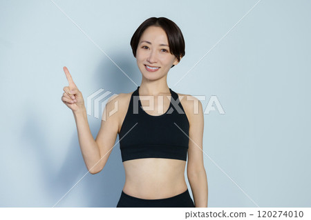 A woman in gym wear posing in the number 1 position on a white background 120274010