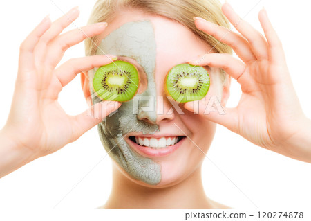 Skin care. Woman in clay mask with kiwi on face 120274878