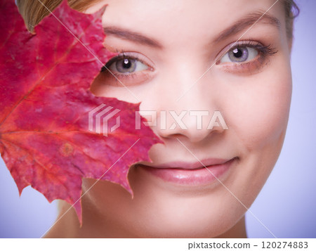 Skin care. Portrait of young woman girl with red maple leaf. 120274883