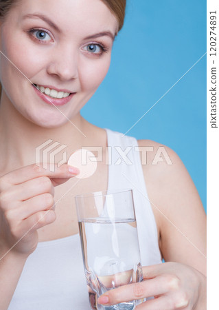 Woman holding glass with water and effervescent tablet Woman holding glass with water and effervescent tablet 120274891